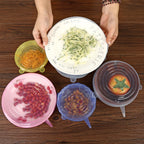 Colorful silicone lids on bowls with food on a wooden surface