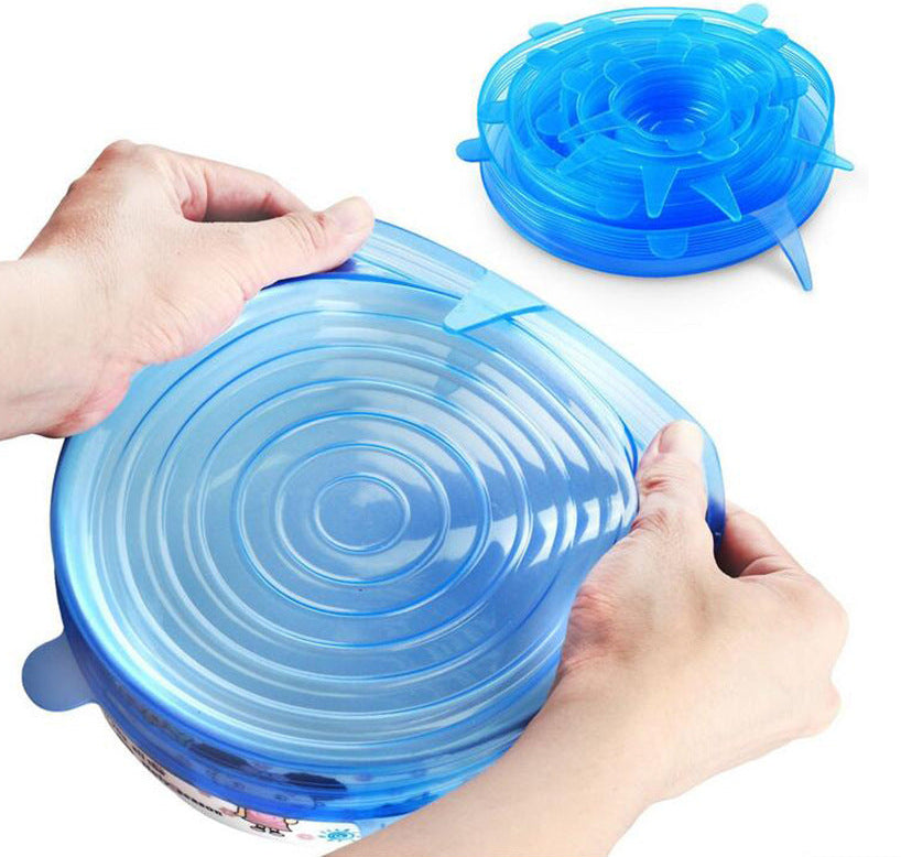 Blue silicone lid being stretched over a container by hands on a white background