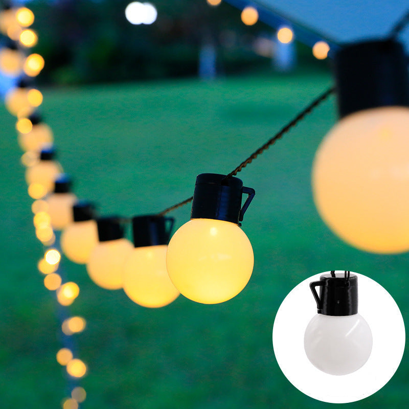 String of outdoor lights with black and white bulb design on a green background