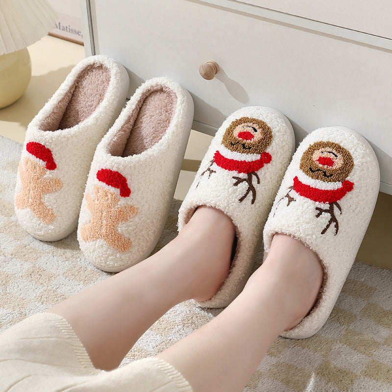 White slippers with Christmas-themed designs on a soft surface