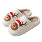 Pair of white slippers with reindeer face design on a white background